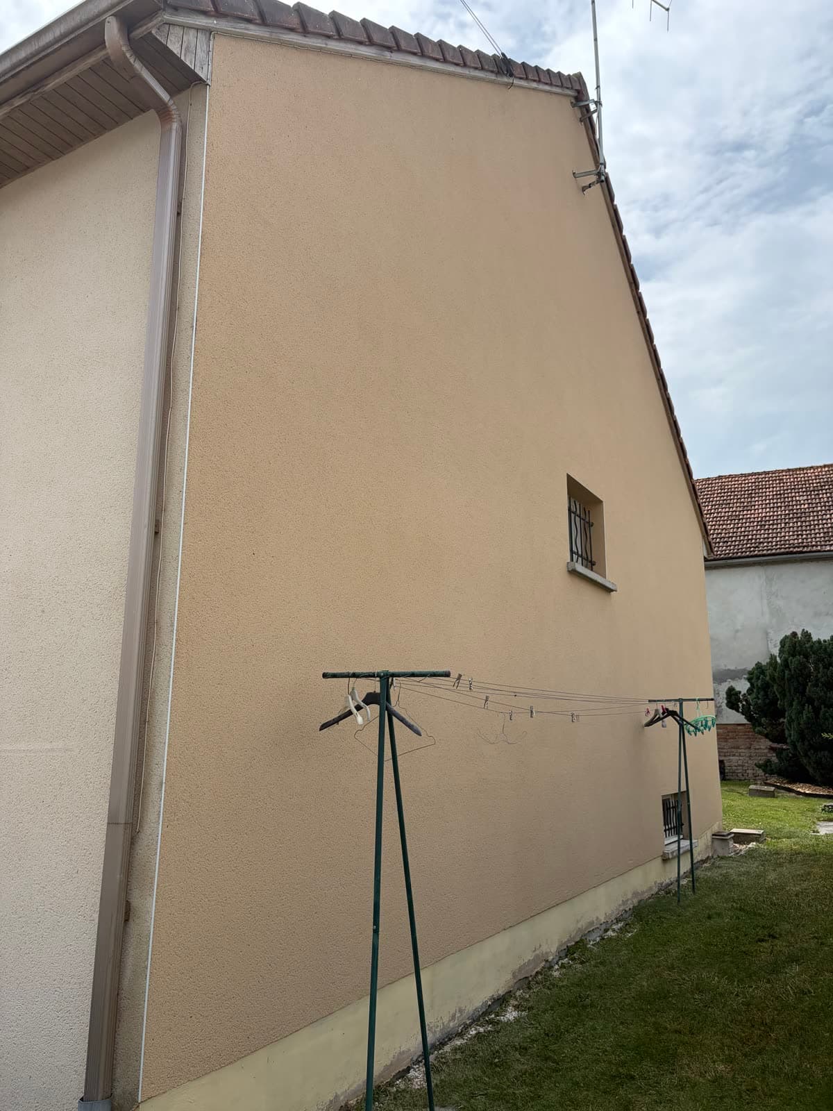 Le même mur pignon après nettoyage de façade : enduit clair et uniforme