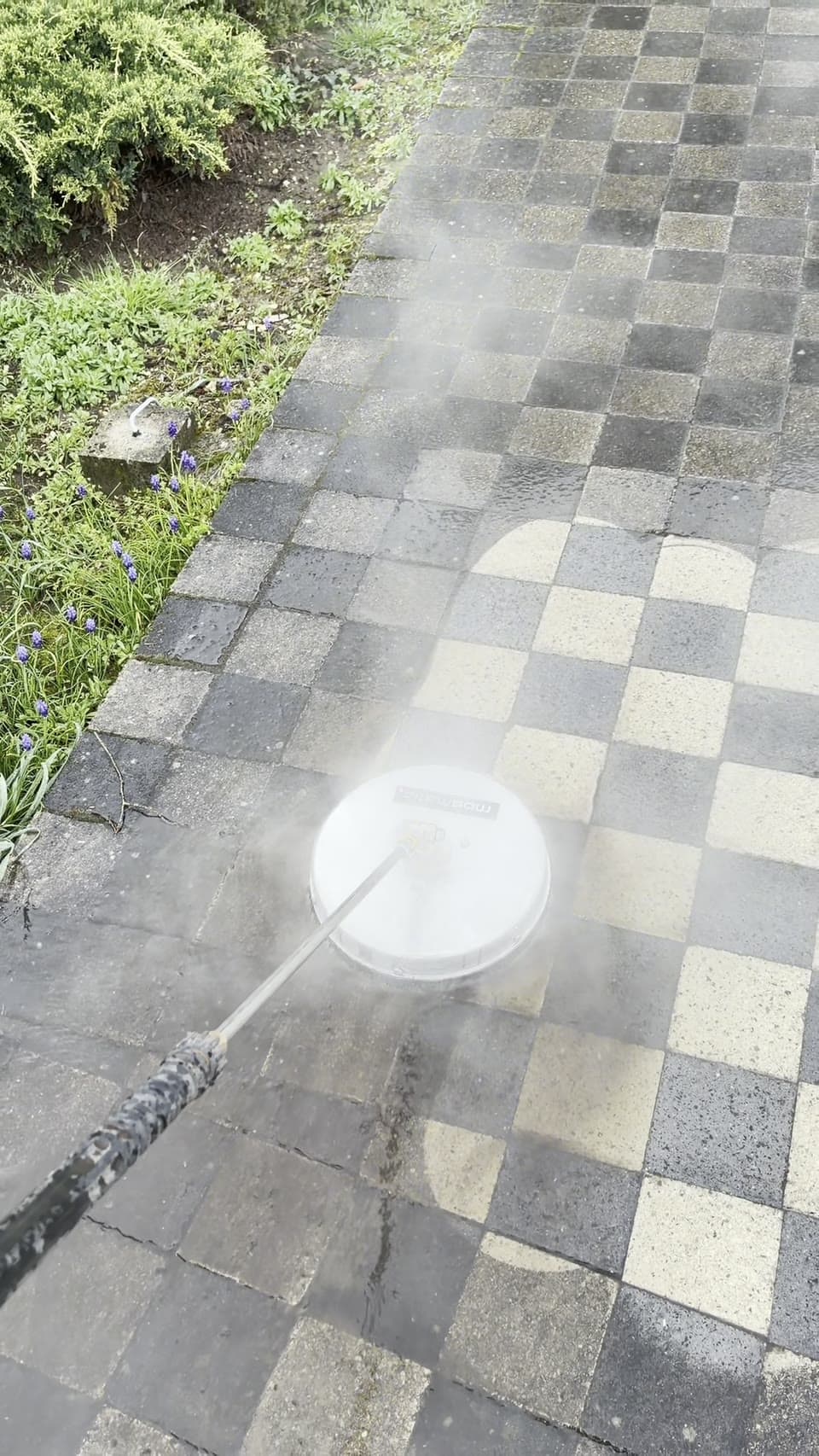 Nettoyage d'une terrasse en pavés dans l'Aisne : dalles encore encrassées d'un côté, pavés remis à neuf de l'autre